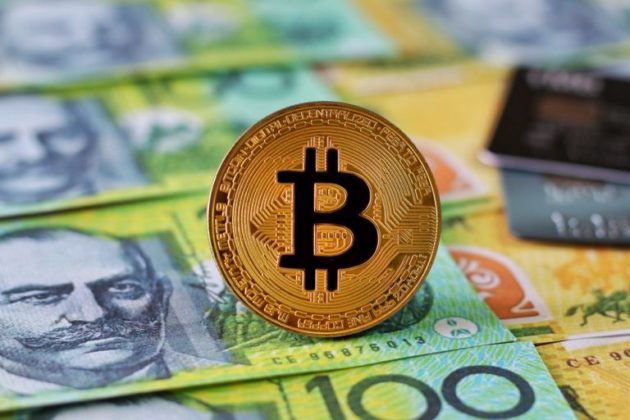 Physical illustration of Bitcoin is standing on the top of Australian Dollars