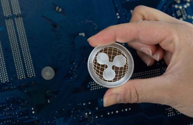 A person is holding a model of Ripple (XRP) token