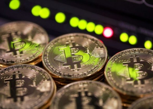 Bitcoin is illustrated as physical coins with green lights and red light behind them