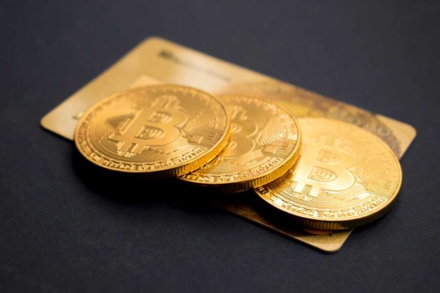 Bitcoin is illustrated as physical gold coins and placed over a gold card