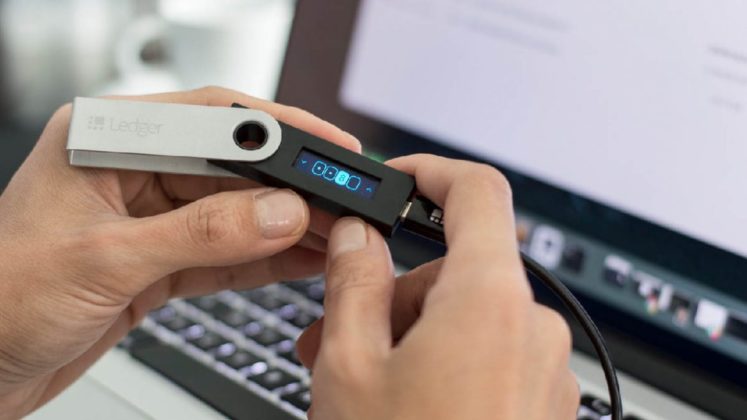 The picture of a person who is using Ledger crypto hardware wallet
