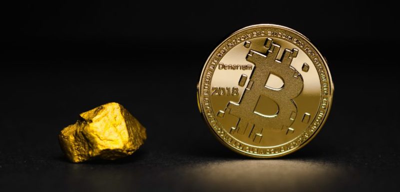 Gold nugget sitting next to Bitcoin physical coin NZ with black back ground