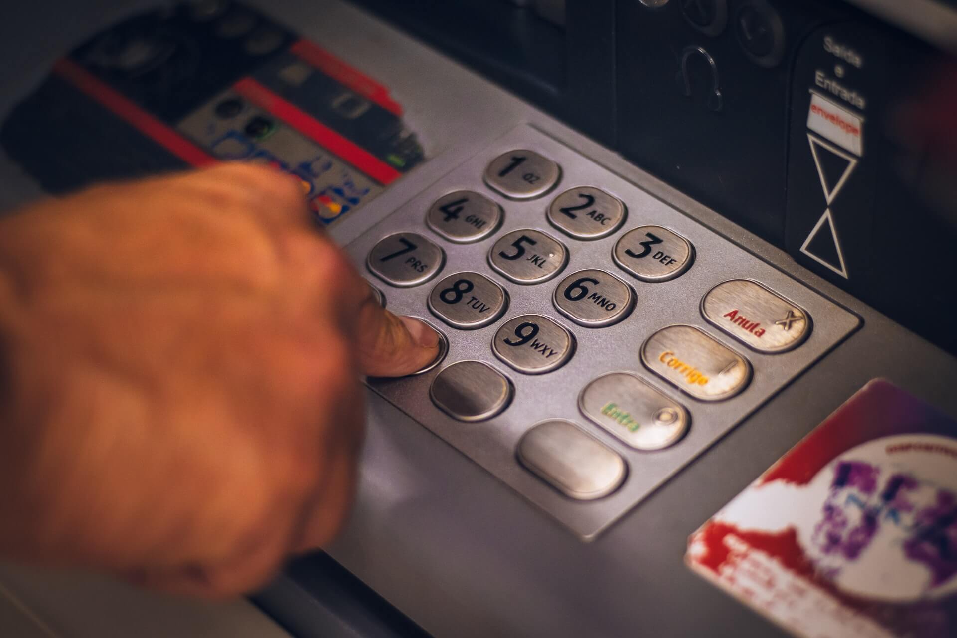 Close up photo of person inputting pin at an atm machine