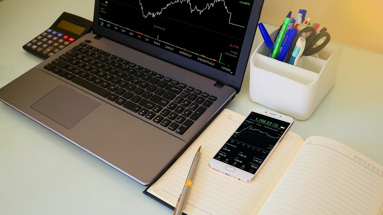 Image of a financial chart on a laptop with a phone next to it