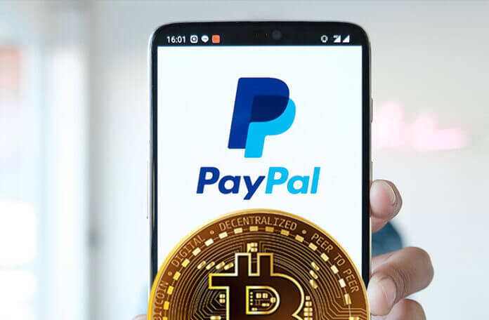 Image of smartphone with the paypal logo displayed on the screen and a golden bitcoin in front of it