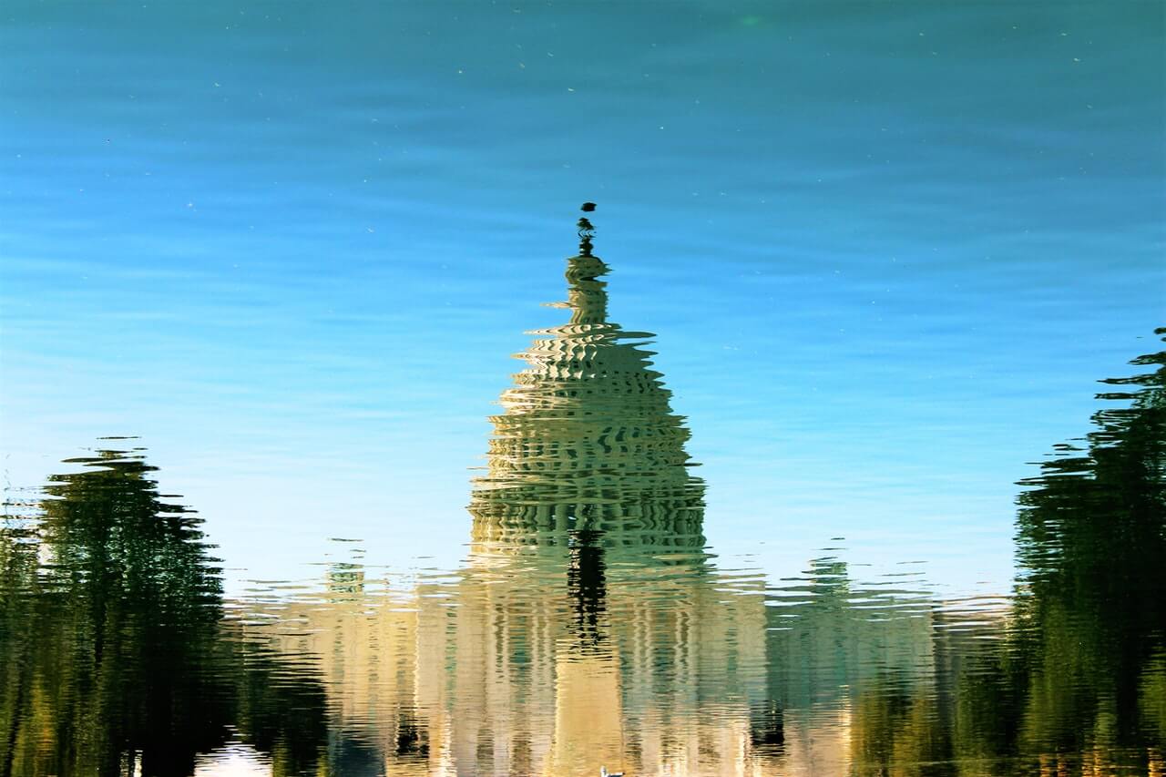 Reflection of a government building upside down to illustrate the importance of a guide to decentralized finance