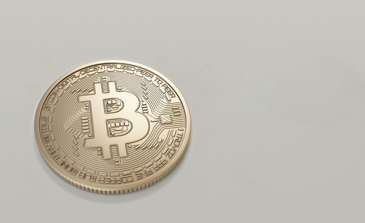 Image of a golden bitcoin backdropped by a beige canvas
