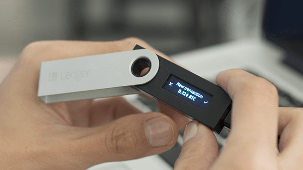 Ledger Nano S being held in the hand
