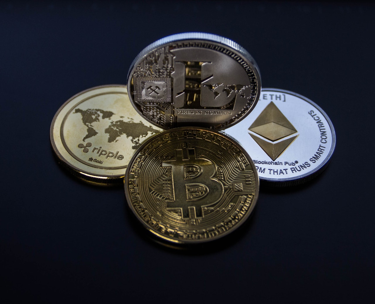 Photo of 4 assorted cryptocurrency coins to illustrate cryptocurrency wallets