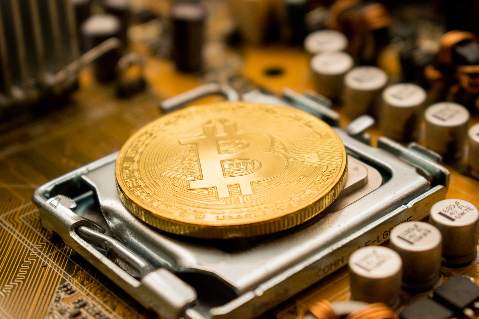 Image of physical bitcoin surrounded by circuitry.