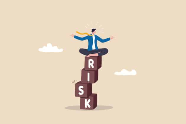 Illustration of a man balancing on top of blocks that spell out RISK
