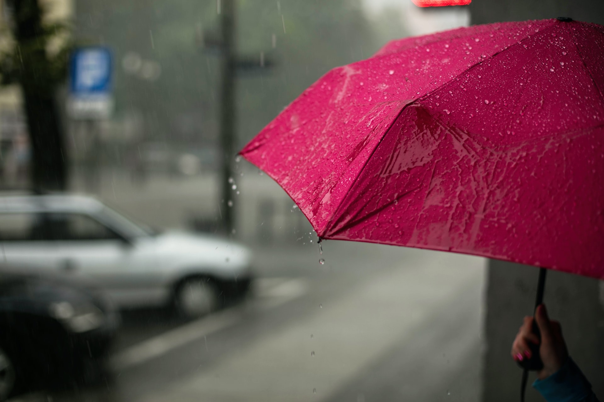 Red umbrella shielding someone from the rain.