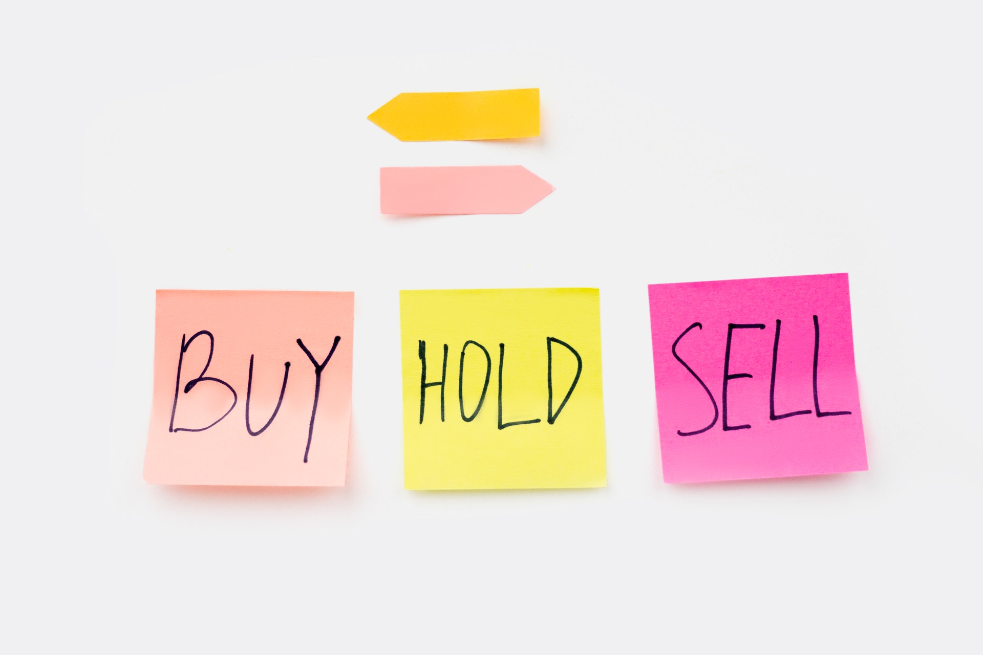 3 post it notes labeled Buy, Hold, and Sell