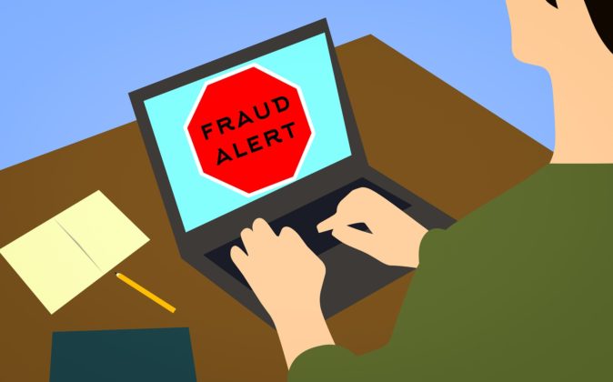 Illustration of a laptop on a desk with a fraud warning displayed on the screen.