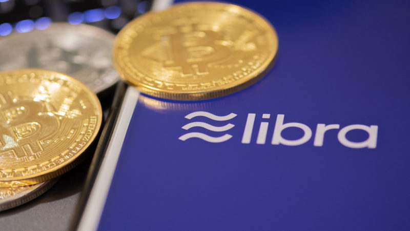 Facebooks-libra-cryptocurrency-app-on-iphone-with-bitcoin-coins-on-it