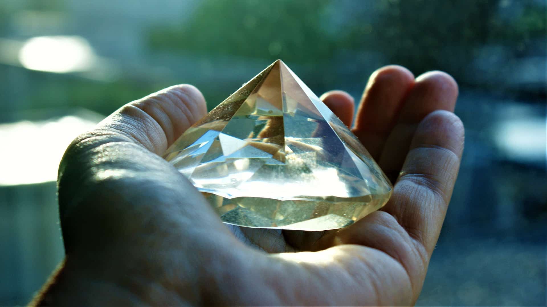 A hand that is holding a large diamond.