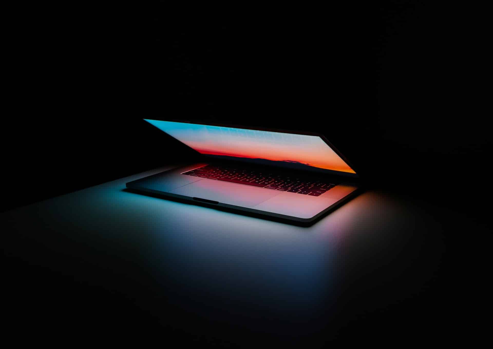 Macbook closing in a dark room.