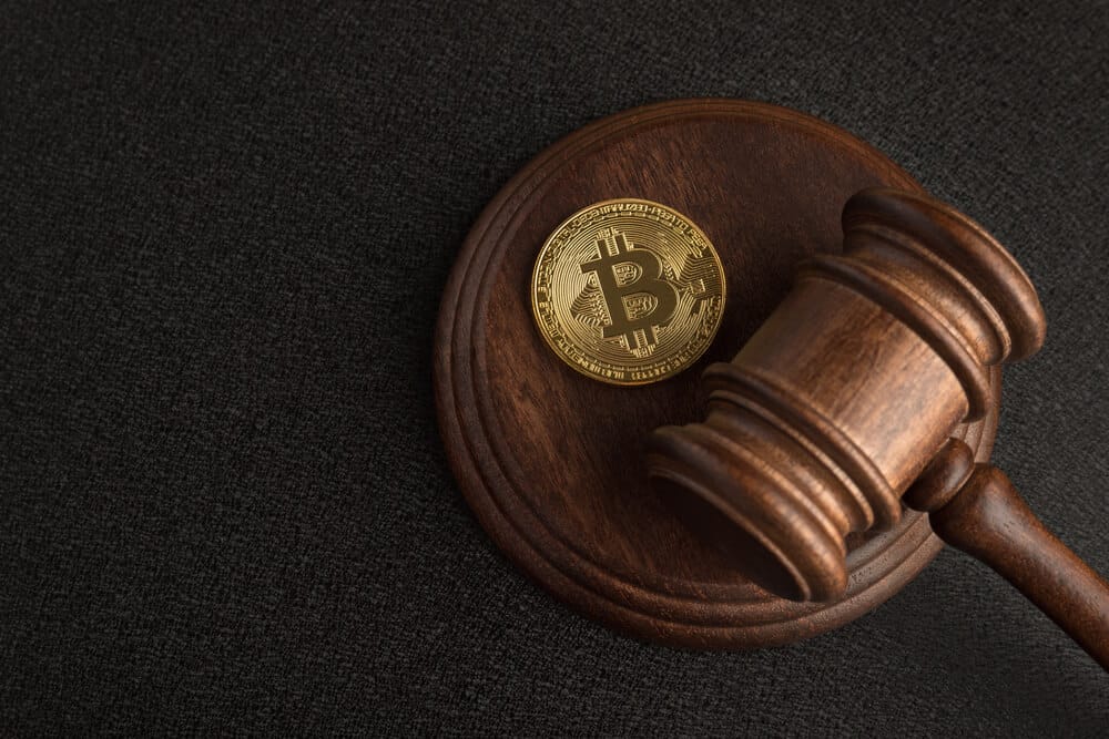 Photo of Bitcoin with a judge's hammer.