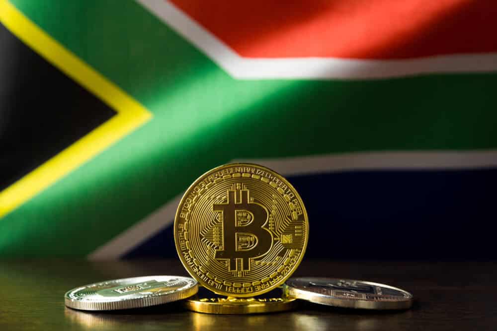 Physical Bitcoin showcased in front of the South African flag