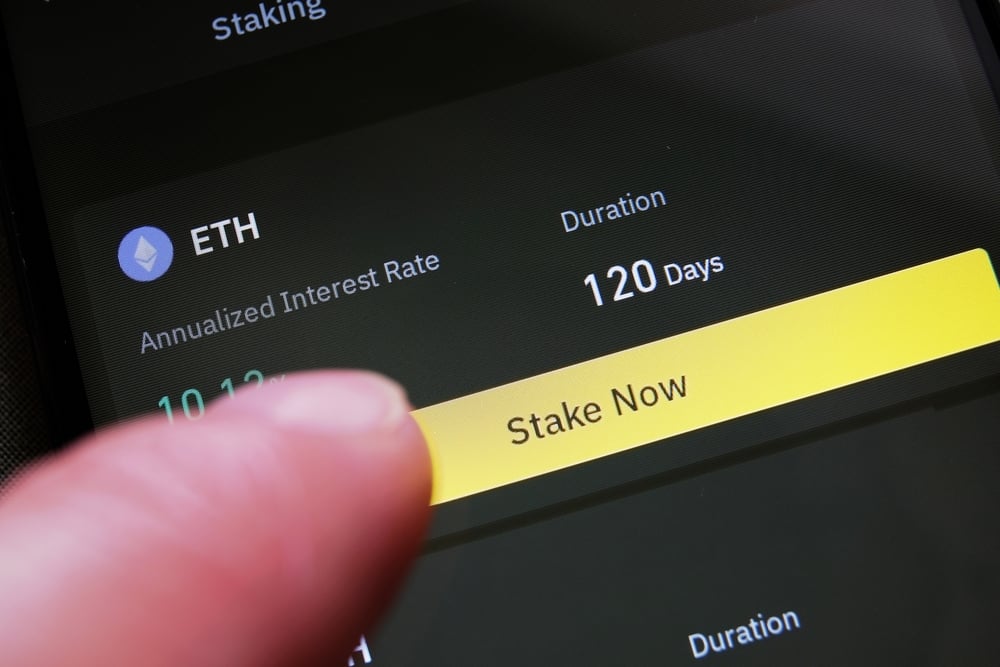 Photo of finger about to press crypto staking button.