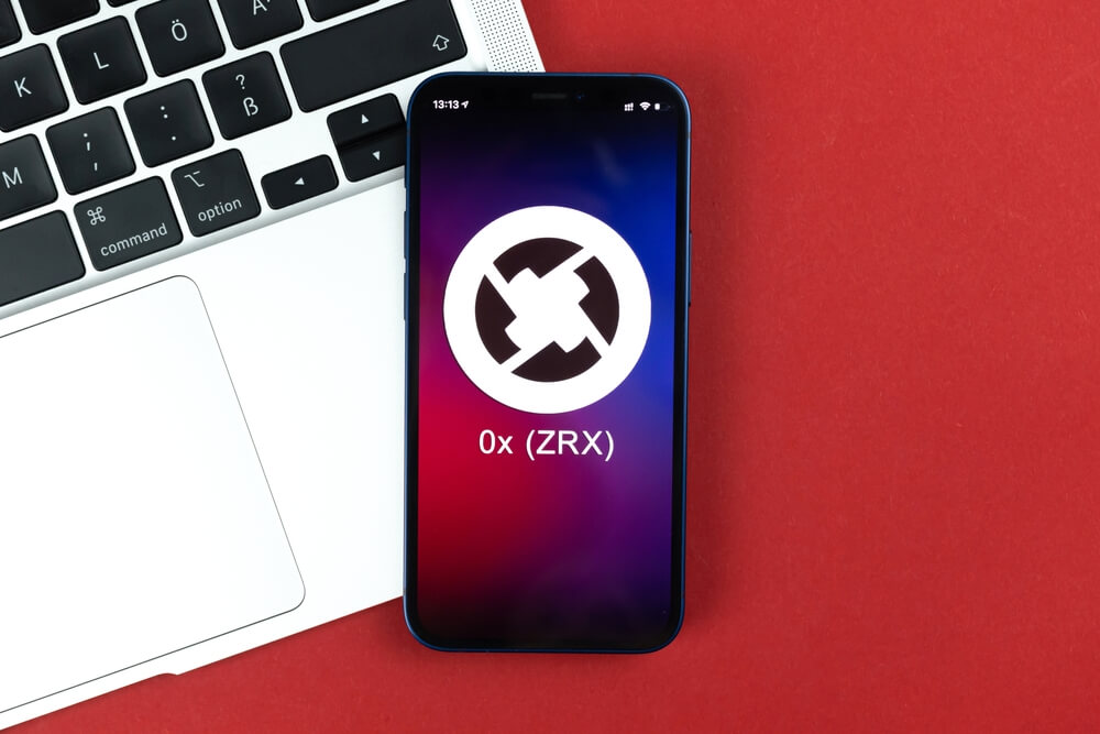 0x ZRX logo on phone screen on red background