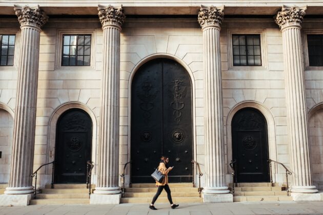 Woman walking in front of a bank entrance