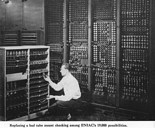 A man replacing a capacitor of an ancient computer.